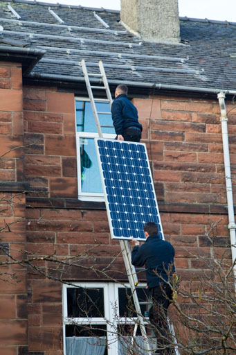 Lifting Topsola PV solar panel on to the roof